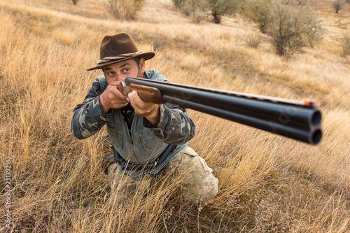 Hunter with a hat and a gun in search of prey in the steppe