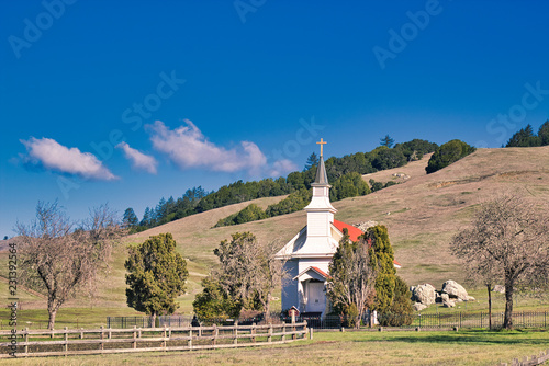 Small rural church at the base of rolling hills in Nicasio, CA (USA) photo