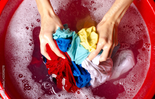 Women washing color clothes in basin enemale powdered detergent, top view © Kabardins photo