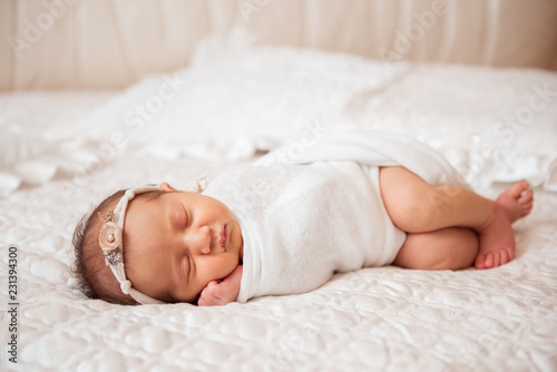Cute newborn baby is sleeping on a big bed. Copy space and top view