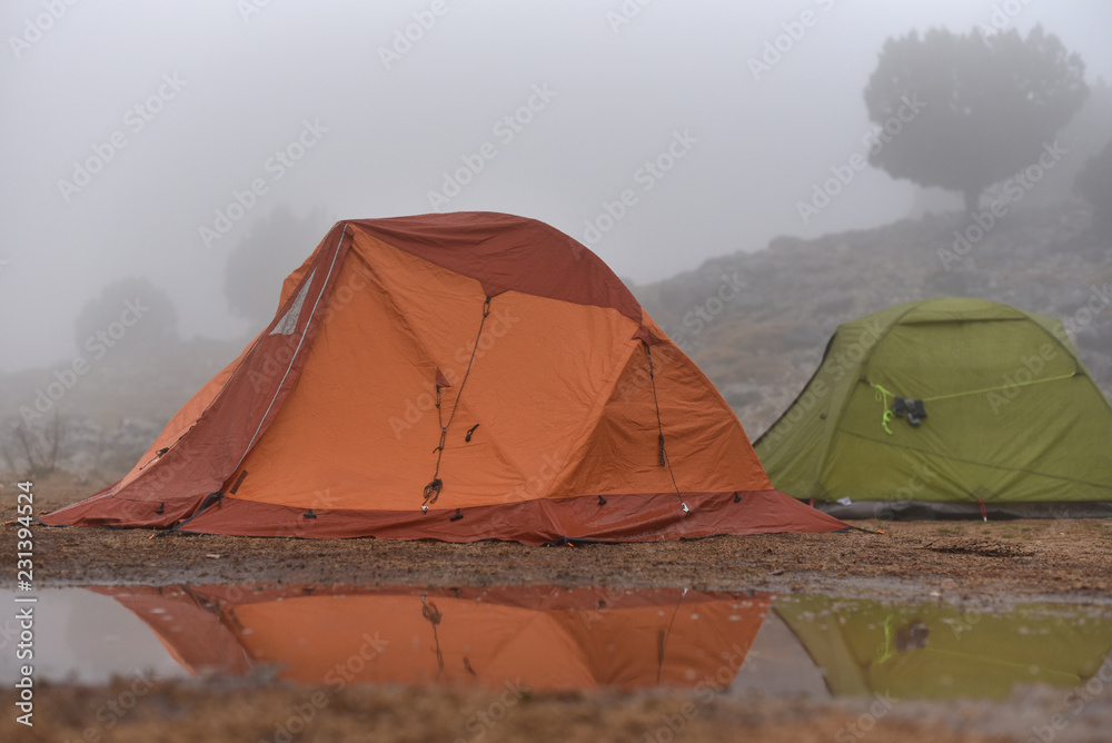 hiker tents in mountains in rain
