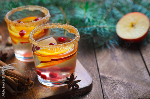 Winter Cocktail, Christmas Sangria with Apple Slices, Orange, Cranberry and Spices, Refreshing Drink on Wooden Background