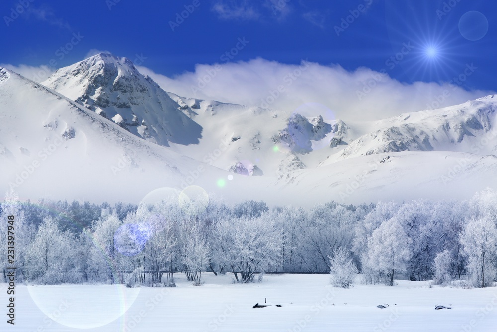 Winter landscape with a road, trees and mountains covered with a fresh layer of white snow and with a blue sky
