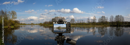 Camera and Panoramic landscape with water, blue sky with white clouds made in Poland by the Bug river