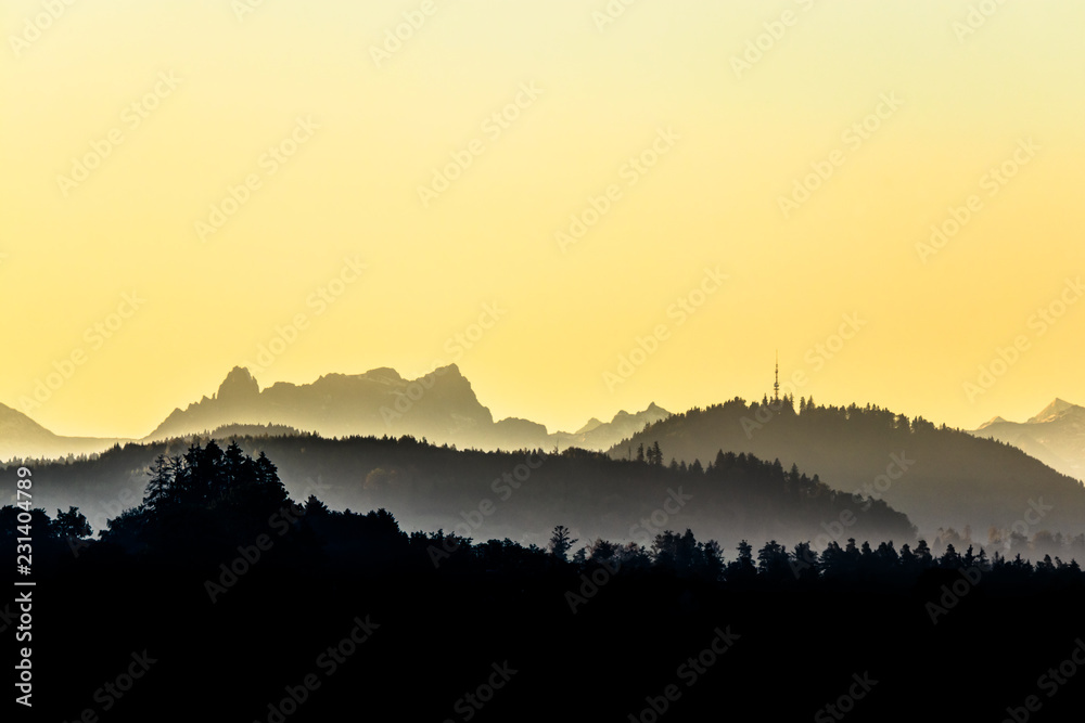 Faded misty hills and mountain range before sunrise, Mürtschenstoch and Bachtel