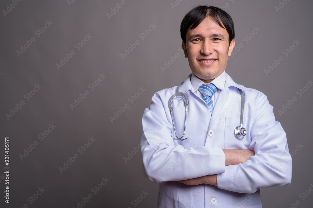 Young Asian man doctor against gray background Young Asian man doctor against gray background
