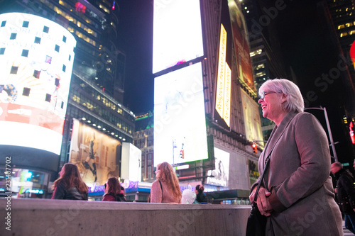 Happy mature woman with white hair having fun on vacation in Times Square