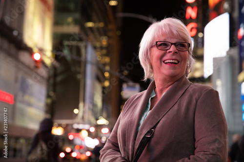 Happy mature woman with white hair having fun on vacation in Times Square