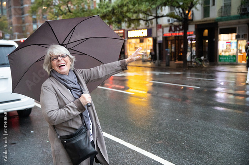 Mature senior white haired woman waiting for taxi cab in New York