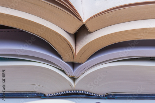 Open books stack close up on white desk