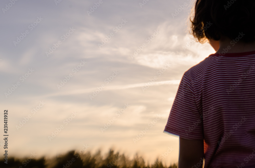 niño mirando el campo al atardecer niño mirando el campo al atardecer