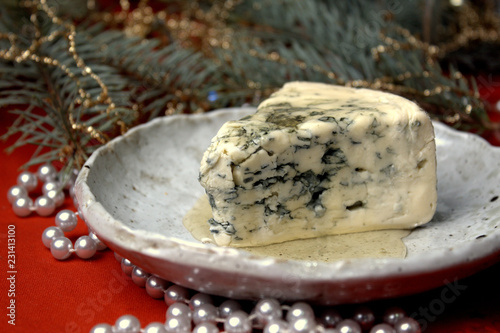 a piece of cheese with mold on a festive New Year's table selective focus. photo