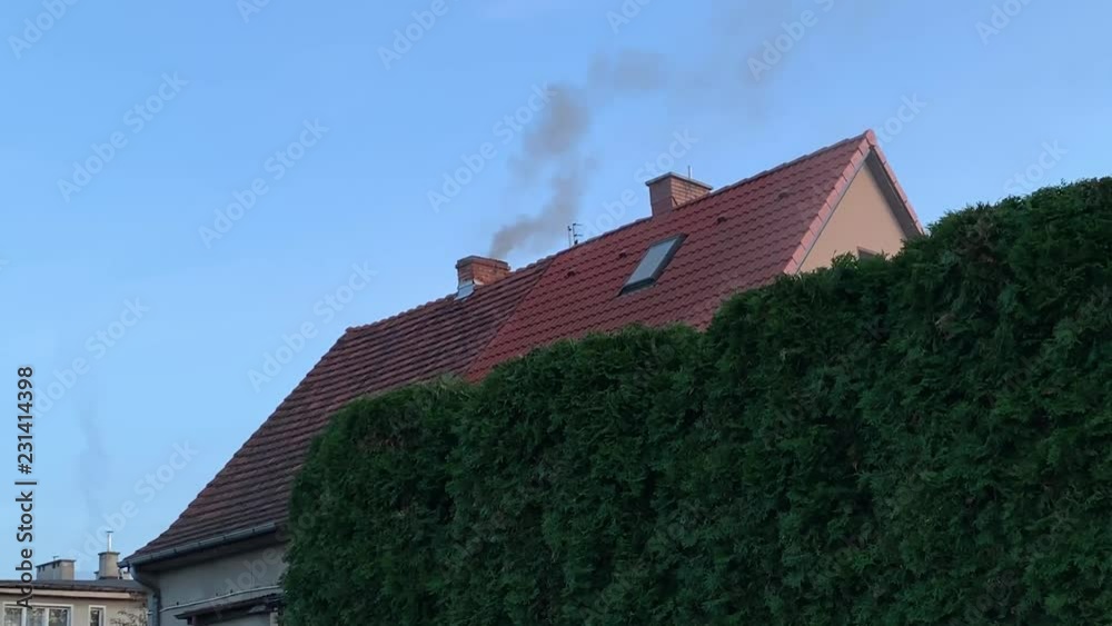 Smoke comes from the chimney of the country house against the blue sky. Smoke comes from the chimney of the country house against the blue sky.