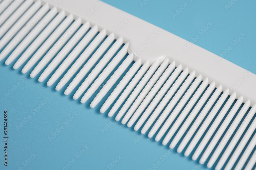 White hair comb isolated on blue background White hair comb isolated on blue background