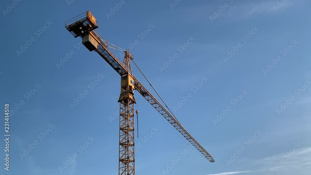 High tower yellow construction crane against the blue sky. High tower yellow construction crane against the blue sky.