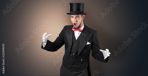 Foto Handsome magician with no graph holds something invisible