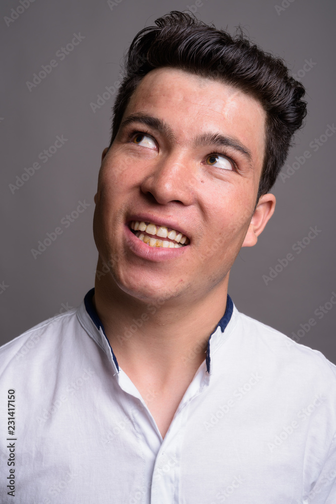 Portrait of young Asian businessman against gray background Portrait of young Asian businessman against gray background