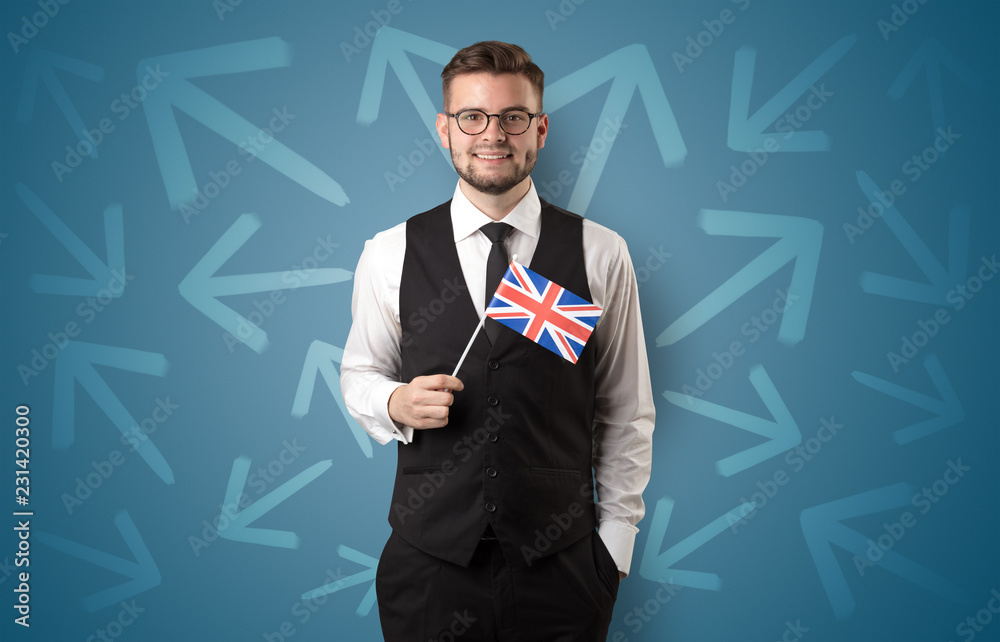 Cheerful elegant boy standing with flag on his hand and chalk drawn arrows around Cheerful elegant boy standing with flag on his hand and chalk drawn arrows around