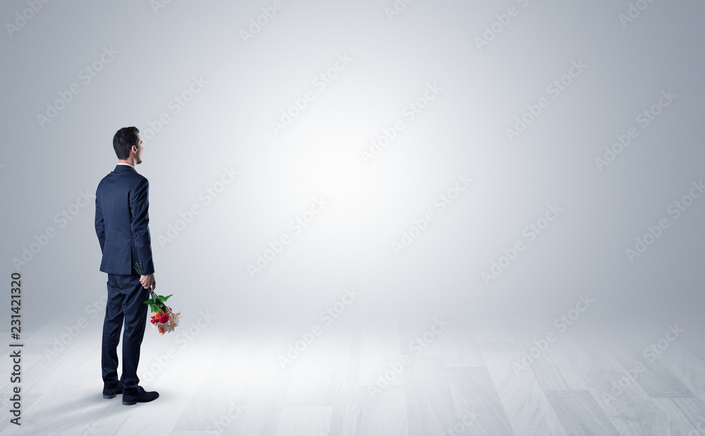 Man standing with his back in an empty room with object in his hand Man standing with his back in an empty room with object in his hand