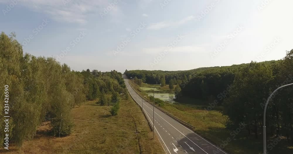 Aerial view of highway in autumn forest. On bridge over ravine and forest lake Aerial view of highway in autumn forest. On bridge over ravine and forest lake