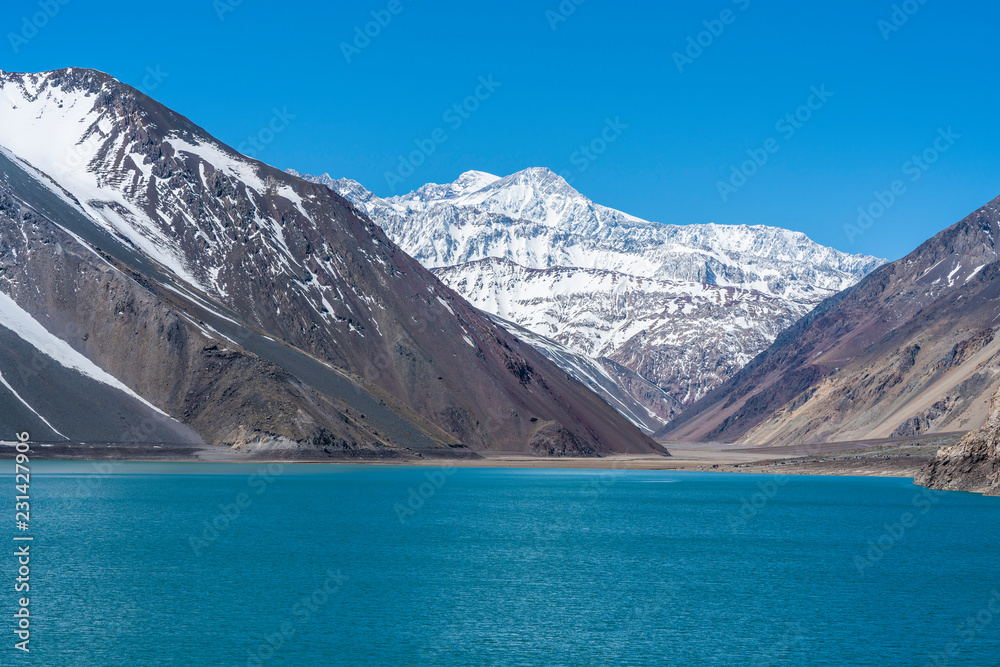 Embalse del Yeso (Yeso Dam) awe high altitude turquoise waters lake inside an amazing rugged landscape. Steep mountains on an awe scenery with the river stopped by the dam inside a valley surrounded b