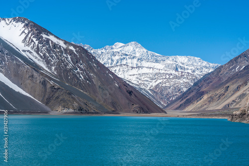 Fototapeta Naklejka Na Ścianę i Meble -  Embalse del Yeso (Yeso Dam) awe high altitude turquoise waters lake inside an amazing rugged landscape. Steep mountains on an awe scenery with the river stopped by the dam inside a valley surrounded b