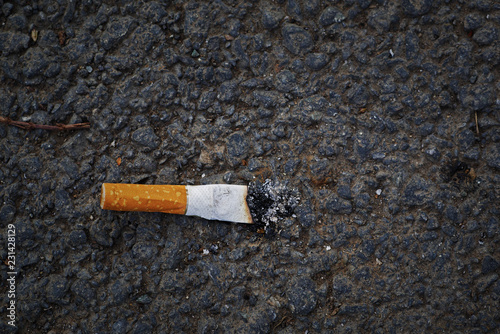 closeup of smashed cigarette butt on asphalt with copy space