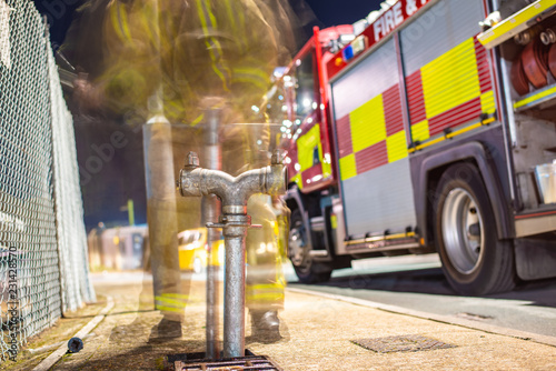 UK fireman extracting water from a hydrant in to fire engine - Long Exposure