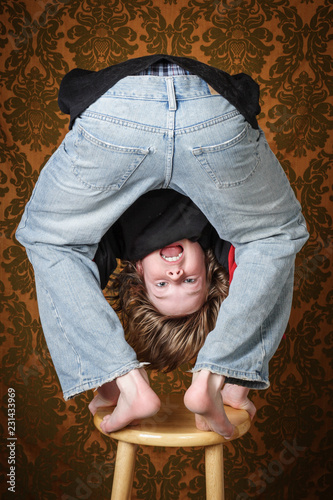 Silly boy upside down on a stool
