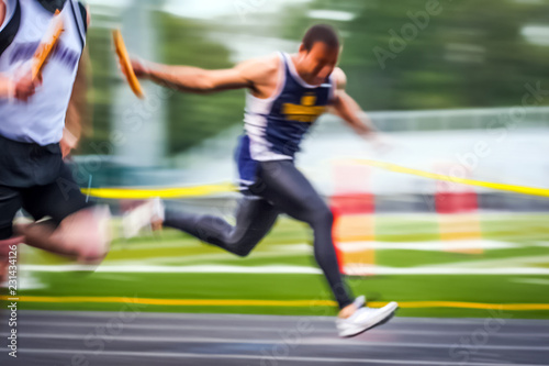 Track and field runner crossing the finish line in a relay race