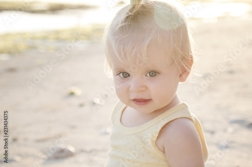  Candid outdoor portrait of cheerful baby at the beach, natural backlight photo