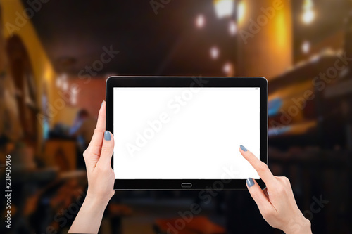 Hand using mock up computer tablet on coffee shop cafe background, with copy space