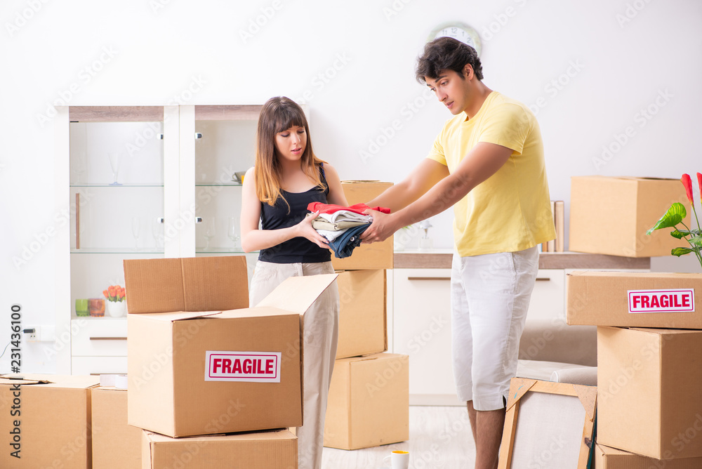 Young couple moving to new flat with fragile things Young couple moving to new flat with fragile things