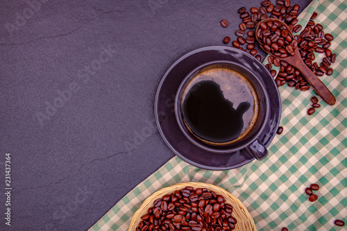 A black coffee in cap with beans and leaves on the black stone with table cloth, for weight loss good health. copy space