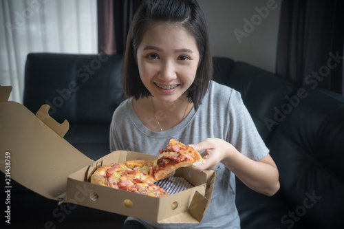 Happy girl eating pizza at home.