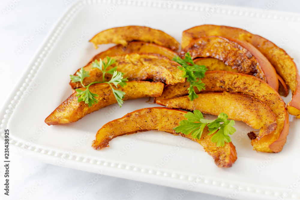 Closeup plate of pumpkin slices with parsley garnish Closeup plate of pumpkin slices with parsley garnish