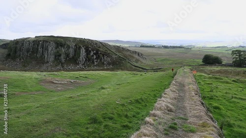 Historic Hadrians Wall rolling hills England Scotland. Hadrian's Wall was a defensive fortification in the Roman province of Britannia built in AD122. One of Britain's ancient tourist attraction. photo