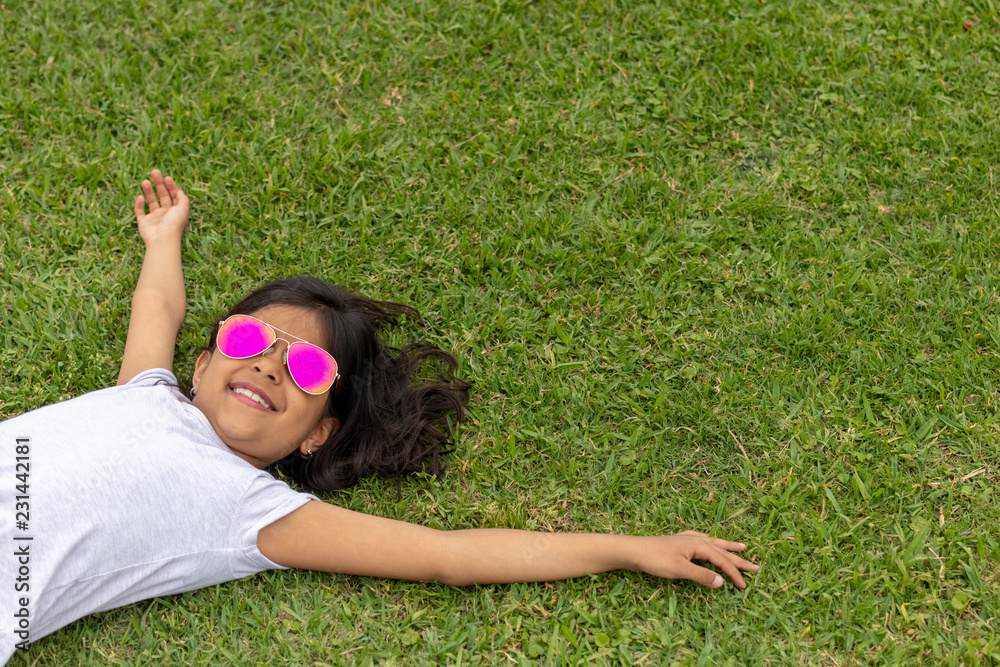 Beautiful girl with sunglasses lying on the grass Beautiful girl with sunglasses lying on the grass