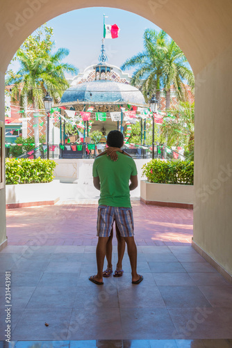 Pareja de enamorados abrazados frente a kiosko de parque central