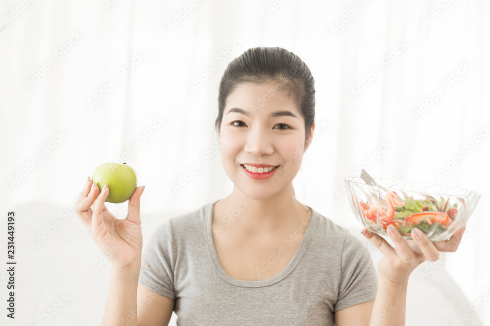 Enjoyed Asian woman eating vegetable salad.