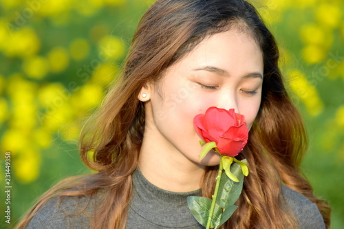 Young Woman Smelling A Rose