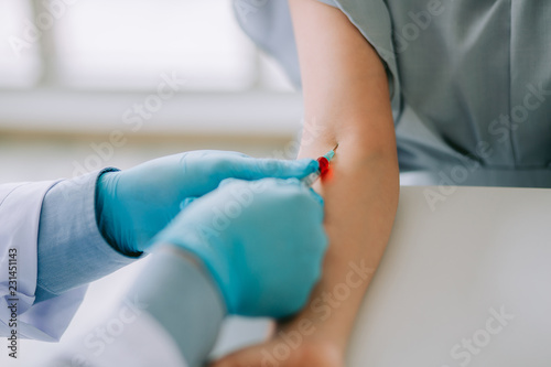 Close up Hand of nurse  doctor or Medical technologist in blue gloves taking blood sample from a patient in the hospital.