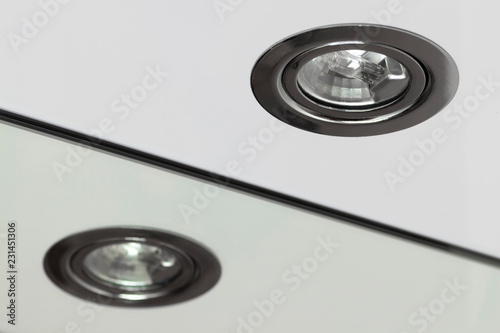Recessed halogen lamp and reflection in the washbasin mirror.