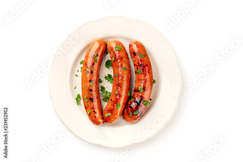 An overhead photo of a plate of fried sausages, shot from above on a white background with a place for text