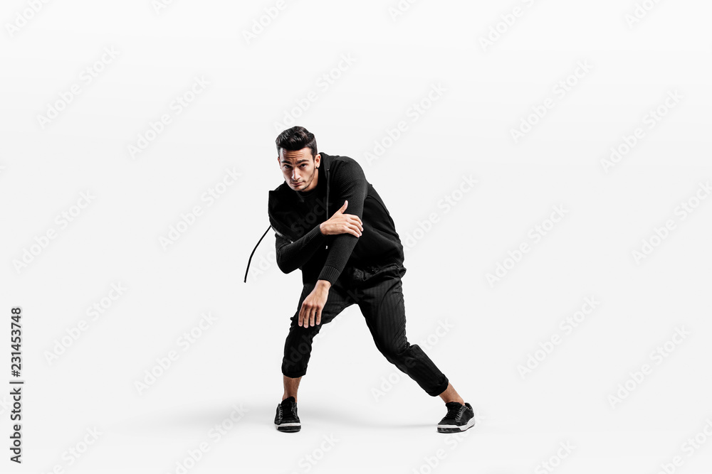 Handsome young dancer wearing a black sweatshirt and black pants is dancing breakdance Handsome young dancer wearing a black sweatshirt and black pants is dancing breakdance