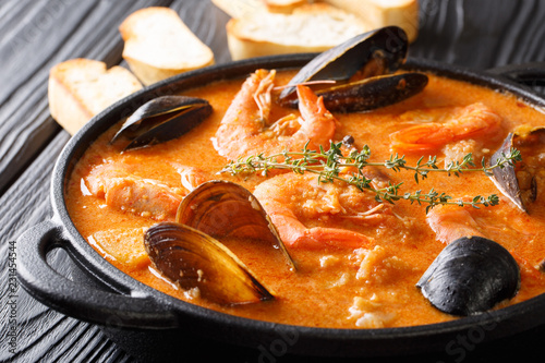 The rich taste of seafood Suquet de Peix soup with potatoes, herbs and fish with the addition of picada close-up in a saucepan. horizontal
