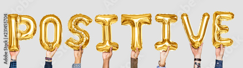 Yellow gold alphabet balloons forming the word positive