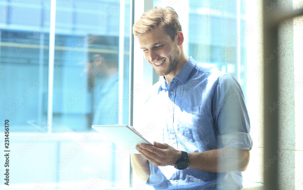 Portrait of young man using tablet in office. Portrait of young man using tablet in office.