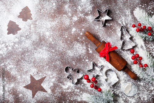 Christmas baking background with flour and rolling pin decorated with fir tree top view.