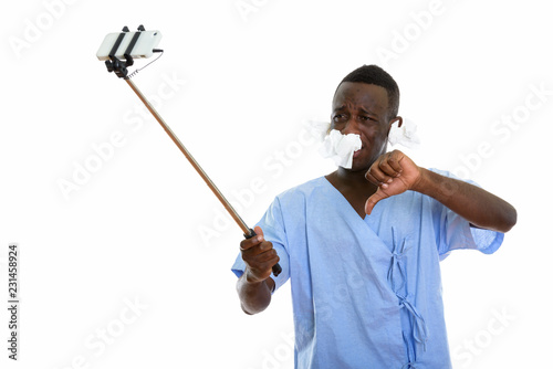 Studio shot of young black African man patient taking selfie pic photo